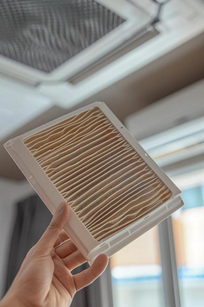Effective DIY Tips for Heat Pump Maintenance and Cleaning 2 Close-up of a clean HVAC air filter held by a homeowner with the heat pump in the background
